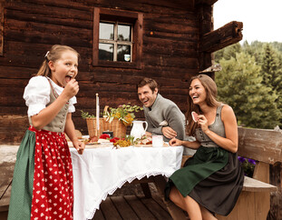 Family having snack at mountain hut in Saalfelden-Leogang