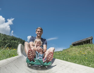 Family at summer tobogganing in Saalfelden-Leogang