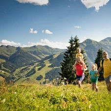 Familie wandert über grüne Wiese