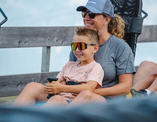 Mutter und Kind fahren gemeinsam mit der Klangrodelbahn am Berg der Sinne in Leogang – Sommerrodelspaß für Familien in Saalfelden Leogang   | © Michael Geißler