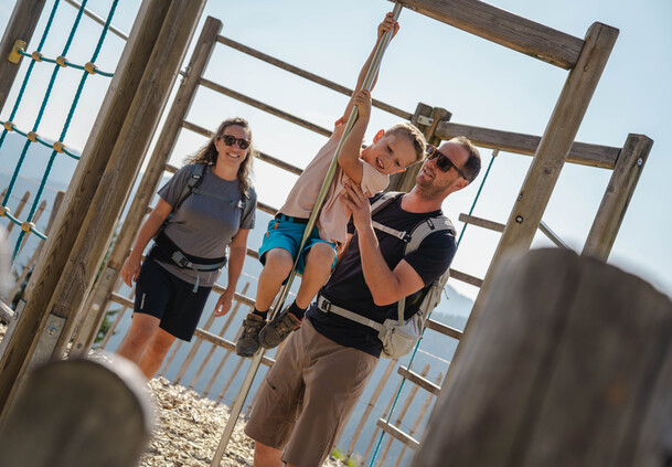 Vater unterstützt sein Kind beim Klettern am Spielplatz am Berg der Sinne in Leogang – gemeinsames Familienerlebnis  | © Michael Geißler