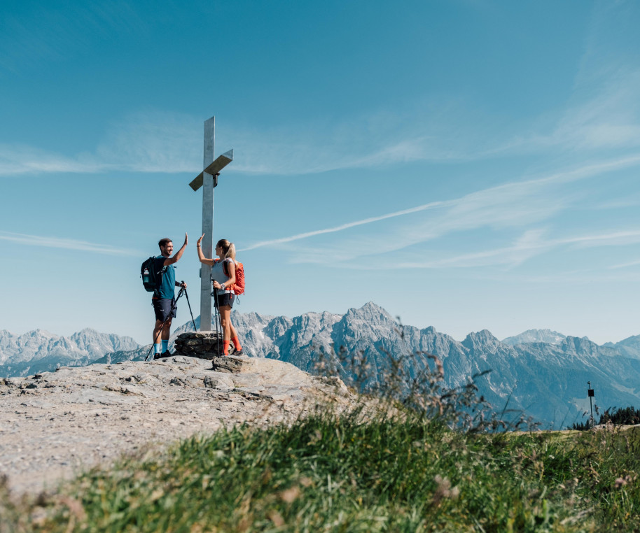 Wanderer beim Gipfelkreuz am Saalachtaler Höhenweg | © Chris Perkles