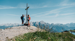 Hiker at the summit cross at the Saalachtaler Höhenweg | © Chris Perkles