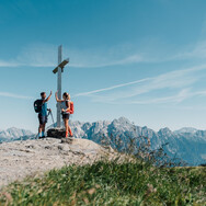 Wanderer beim Gipfelkreuz am Saalachtaler Höhenweg | © Chris Perkles