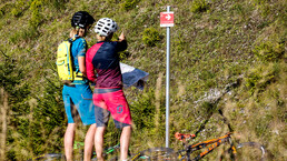 Mountainbiker orientieren sich an Wegpfeilern