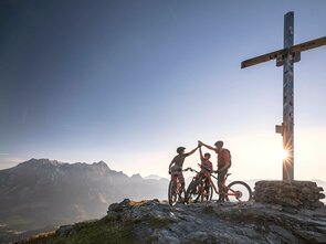 Mountainbiker auf dem Berggipfel bei Sonnenaufgang in Saalfelden-Leogang | © Klemens König