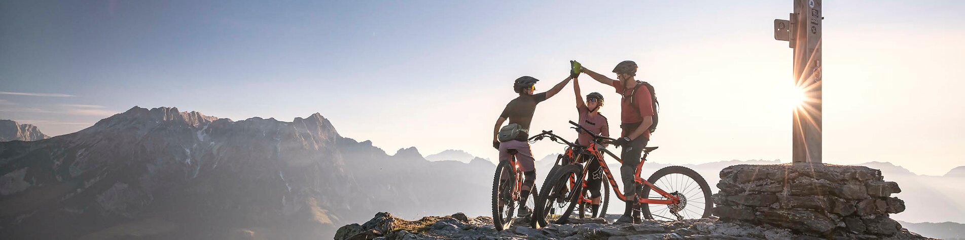 Mountainbiker auf dem Berggipfel bei Sonnenaufgang in Saalfelden-Leogang | © Klemens König