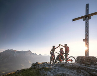 Mountainbiker auf dem Berggipfel bei Sonnenaufgang in Saalfelden-Leogang | © Klemens König