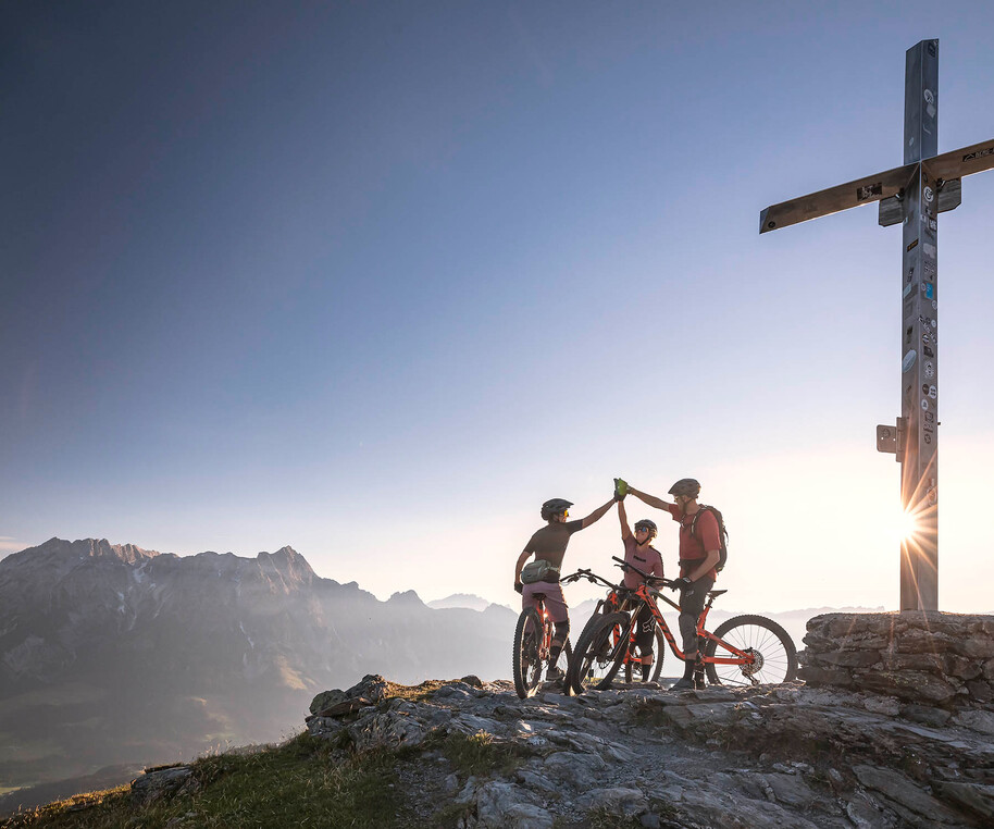 Mountainbiker auf dem Berggipfel bei Sonnenaufgang in Saalfelden-Leogang | © Klemens König