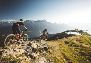 Mountainbiker im Sonnenaufgang über dem Speicherteich am Asitz | © Klemens König