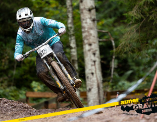 Austrian Gravity Series – Rennfieber im Bikepark Leogang | © Austrian Gravity Series Mountainbiker mit Startnummer 162 meistert eine technisch anspruchsvolle Kurve auf der nassen Rennstrecke der Austrian Gravity Series, mit Fokus und Speed. | © Austrian Gravity Series