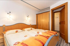 Schlafzimmer_mit_Türe_zum_Bad_und_Wohnküche