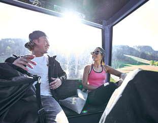 Besucher in der Gondel auf dem Weg zum Flying Fox XXL in Leogang