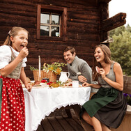 Familie bei der Jause auf der Berghütte in Saalfelden-Leogang