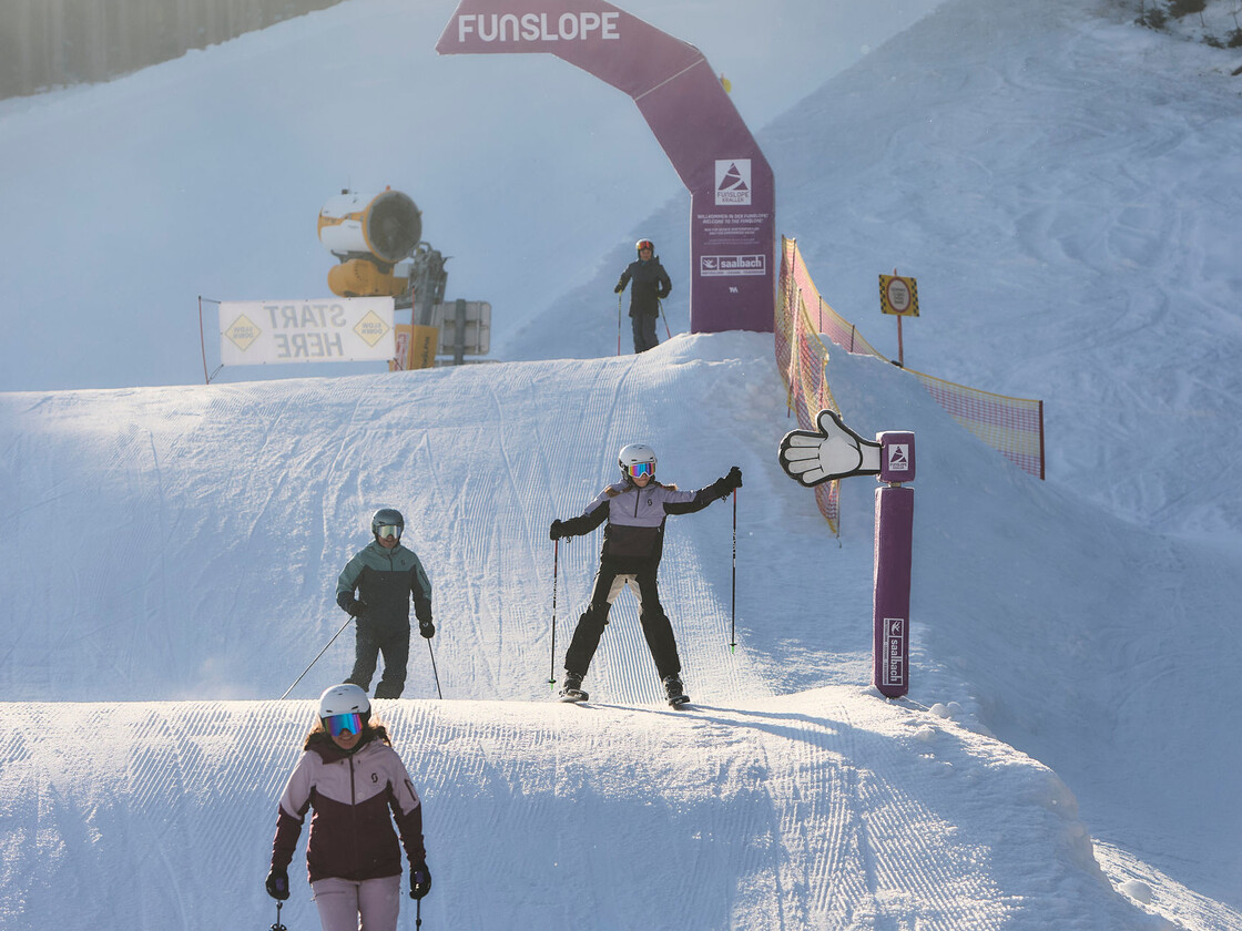 Skifahrer starten unter dem Funcross-Bogen am Schanteilift in Leogang und genießen die abwechslungsreiche Strecke mit Wellen und Kurven. | © Daniel Roos
