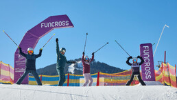 Vier Skifahrer jubeln unter dem Funcross-Bogen am Schanteilift in Leogang und genießen das Familienangebot im Skicircus Saalbach Hinterglemm Leogang Fieberbrunn. | © Daniel Roos