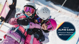 Familienzeit auf Ski im Kinderland Leogang. Eine Mutter umarmt ihre zwei Kinder. | © Michael Geißler