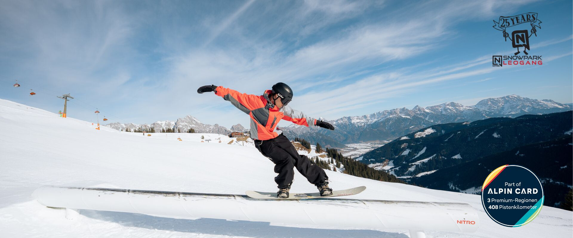 Snowboarder fährt über eine Box im Nitro Snowpark Leogang vor alpiner Bergkulisse bei Sonnenschein | © Miriam Lottes